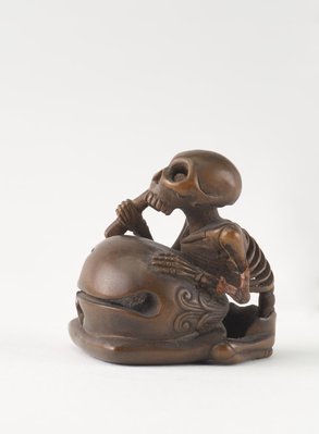 Alternate image of Netsuke in the form of a seated skeleton hitting a 'wooden fish' bell ('mokugyo') by 